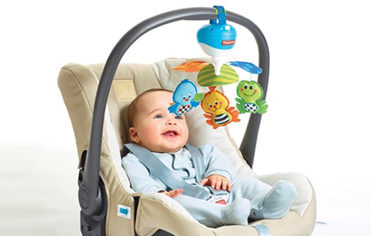 Baby in Babyschale mit Hängespielzeug. Baby in Babyschale mit Hängespielzeug.